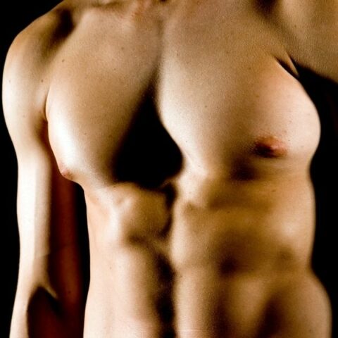 Trans man without a shirt after pectoral implants surgery
